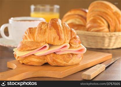 Croissant with ham and cheese (Selective Focus, Focus on the front of the croissant and the ham and cheese slices)