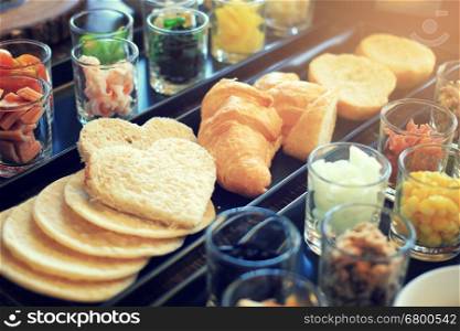 Croissants and breads with various ingredients for breakfast meal