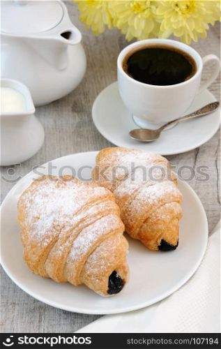 Croissants with chocolate filling cup and fresh morning coffee.
