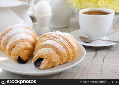 Croissants with chocolate filling cup and fresh morning coffee. Foreground close-up