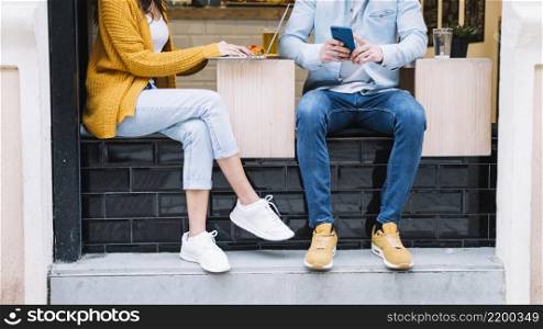 crop couple using smartphone laptop