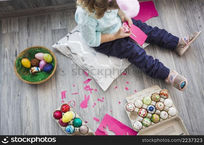 crop girl cutting paper near eggs