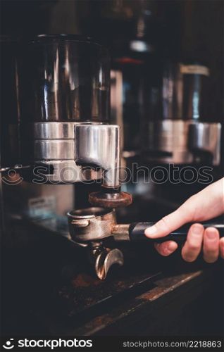 crop hand filling portafilter with coffee