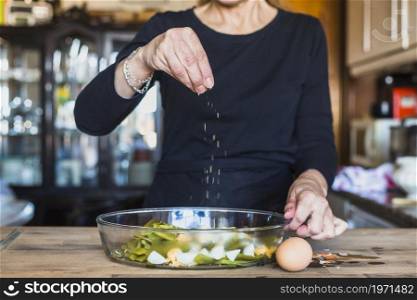 crop hands elderly woman sprinkling dish salt. High resolution photo. crop hands elderly woman sprinkling dish salt. High quality photo