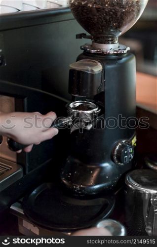 crop hands grinding coffee into portafilter