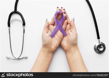crop hands with violet ribbon near stethoscope. High resolution photo. crop hands with violet ribbon near stethoscope. High quality photo