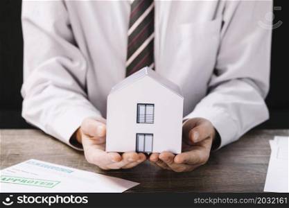crop man holding paper house