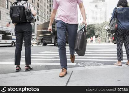 crop man with bag crossing road