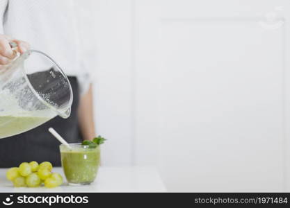 crop person pouring green smoothie glass. High resolution photo. crop person pouring green smoothie glass. High quality photo