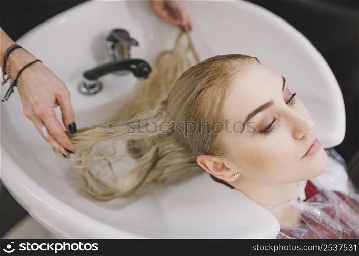 crop stylist washing hair blonde