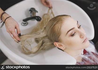 crop stylist washing hair blonde