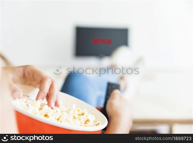 crop woman eating popcorn watching series living room. Resolution and high quality beautiful photo. crop woman eating popcorn watching series living room. High quality beautiful photo concept