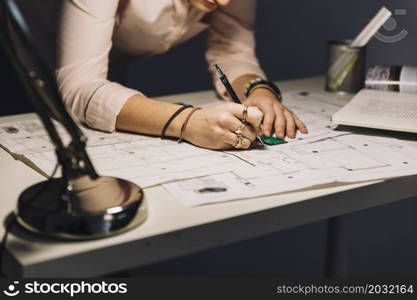 crop woman making blueprints