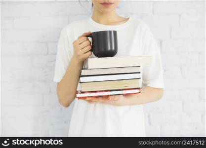 crop woman with books cup