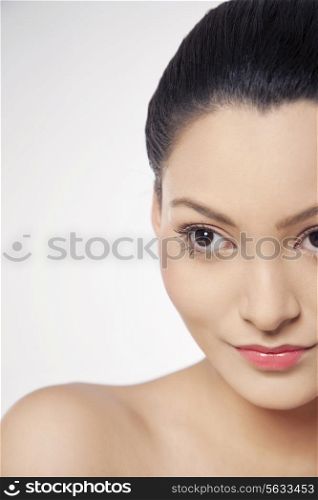 Cropped image of a young woman looking away over white background