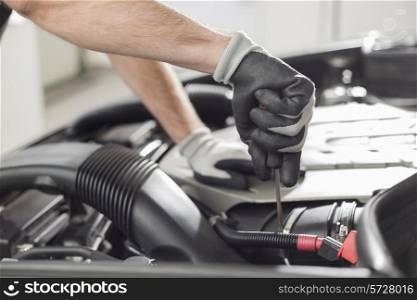 Cropped image of automobile mechanic repairing car in automobile store
