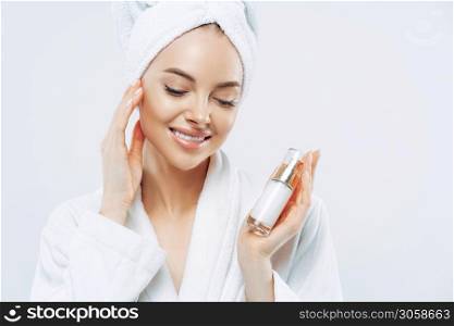 Cropped image of beautiful charming woman touches her smooth skin gently, uses cosmetic product for body care, applies moisturizer after taking bath. Natural cosmetology, face treatment concept