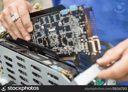 Cropped image of male engineer repairing video card in computer manufacturing industry