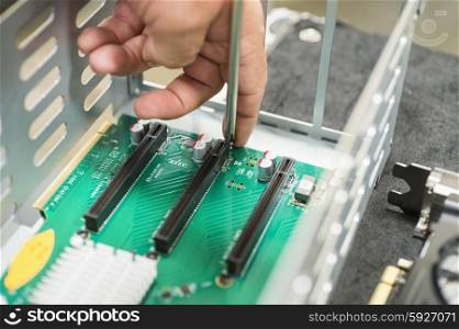Cropped image of male technician repairing PCI slots in computer factory