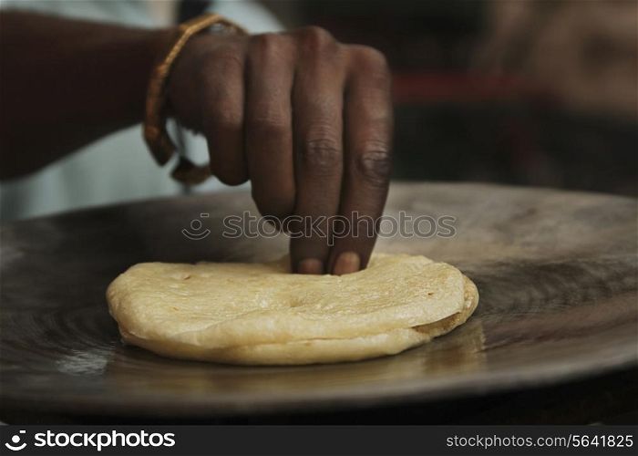Cropped image of male vendor preparing kulcha