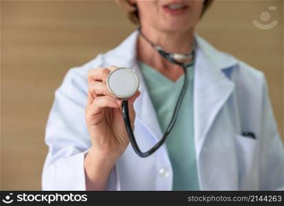 Cropped of female doctor in white coat uniform using medical stethoscope . Healthcare and insurance concept