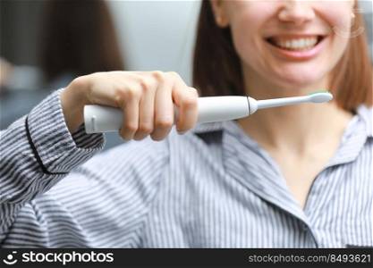 cropped photo of happy healthy smiling woman with ultrasonic electric brush in bathroom at home. Dental hygiene and teeth care.. cropped photo of happy healthy smiling woman with ultrasonic electric brush in bathroom at home. Dental hygiene and teeth care