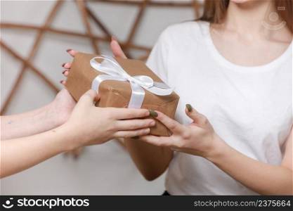 Cropped photo of man had giving a gift box to woman. christmas and new year concept. young boyfriend is giving surprise in box with white ribbon to his girlfriend.. Cropped photo of man had giving a gift box to woman. christmas and new year concept. young boyfriend is giving surprise in box with white ribbon to his girlfriend