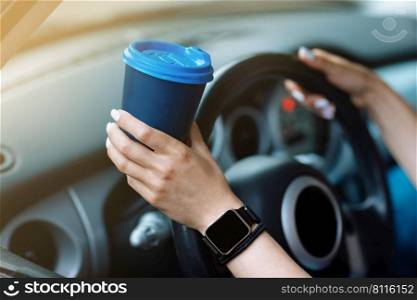 cropped photo of woman’s hand holding blue paper cup of coffee in car. Hot drink take away. Travel with coffee. Concept of coffee with you. Mockup.. cropped photo of woman’s hand holding blue paper cup of coffee in car. Hot drink take away. Travel with coffee. Concept of coffee with you. Mockup