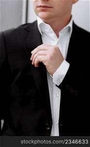 cropped photo of young man in a white shirt and black suit. business portrait. The groom is going to meet the bride. Wedding. businessman. fiance. cropped photo of young man in a white shirt and black suit. business portrait. The groom is going to meet the bride. Wedding. businessman. fiance.
