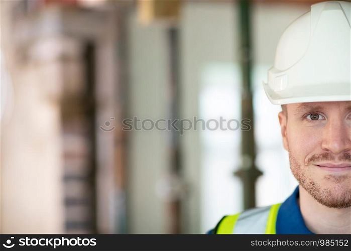 Cropped Portrait Of Male Construction Worker On Building Site Wearing Hard Hat
