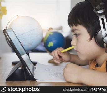 Cropped shot Kid using tablet for his homework,Child using digital tablet searching information on internet during, Home schooling, Social Distance, E-learning online education