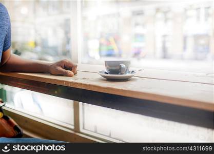 Cropped shot of man at coffee shop window seat