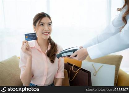 Cropped shot of woman paying with credit card in the shop’s VIP lounge