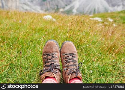 Cropped view of hikers feet wearing hiking books on grass, Austria