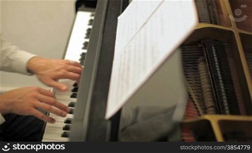 Cropped view of musician playing piano. High angle view