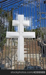 Cross at Christian Orthodox cemetery entrance on a sunny day.