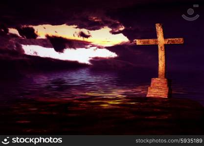cross at sunset with reflection on the water