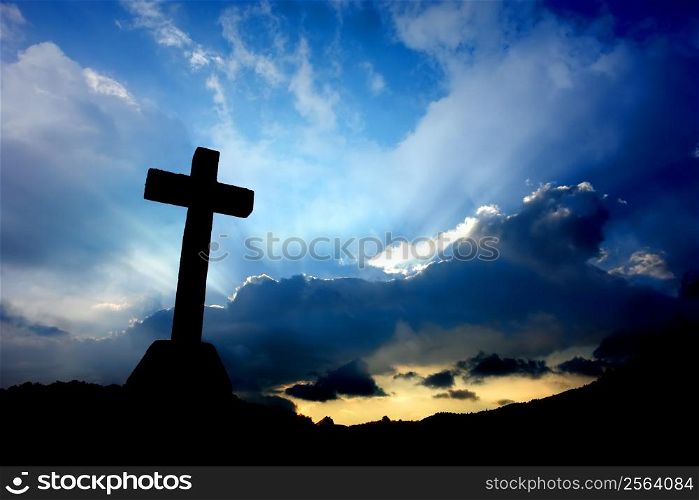 cross detail in silhouette and the clouds in the sky