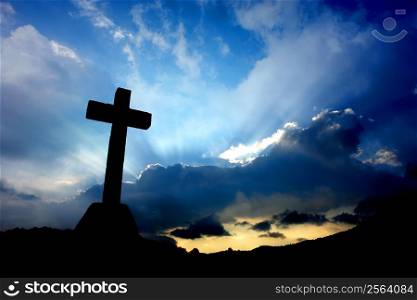 cross detail in silhouette and the clouds in the sky
