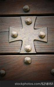 cross lombardy arsago seprio abstract rusty brass brown knocker in a door curch closed wood italy