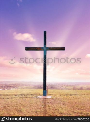 cross of christ in field at sunset or sunrise