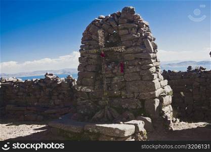 Cross on a stone wall, Lake Titicaca, Taquile Island, Puno, Peru