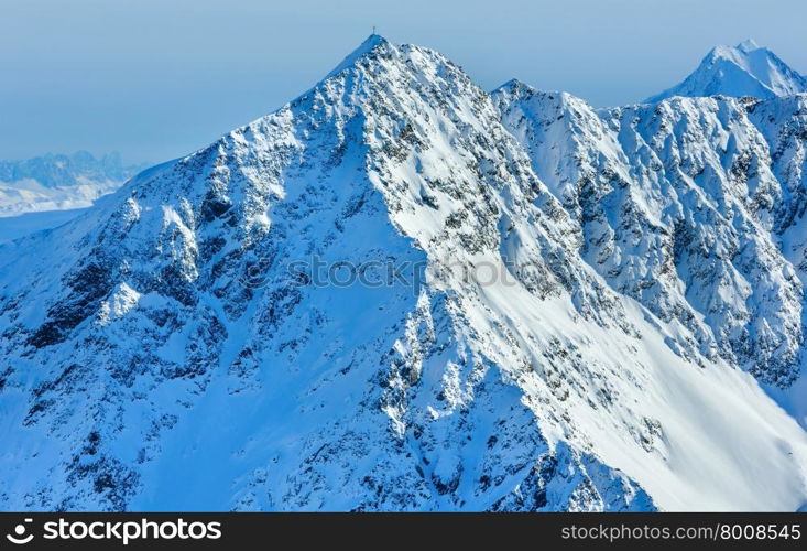 Cross on mount top. Scenery from the cabin ski lift at the snowy slopes (Tyrol, Austria).