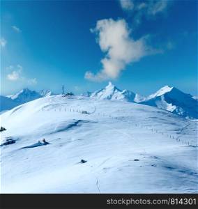 Cross on winter mountain Shneeberg top and view Alps peaks behind, Hochkoenig region, Austria