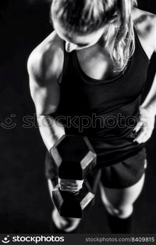 Cross training. Young woman exercising with dumbbells