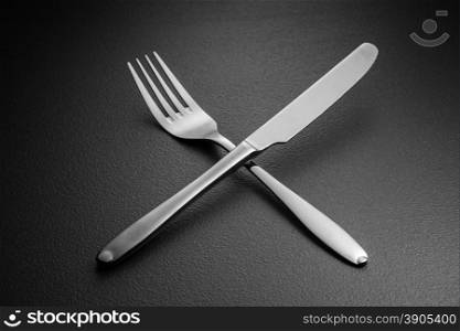 crossed knife and fork on black