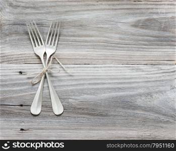 Crossed vintage forks on old wooden boards