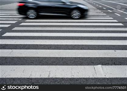 Crosswalk pedestrian crossing with blurred car on asphalt road in the street. Crosswalk pedestrian crossing in the street