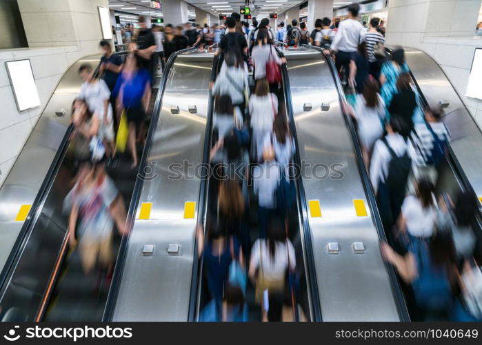 Crowd of Pedestrians Unrecognizable walking in escalator in rush hour morning before working time in subway transportation hub, Hong Kong, Central District, fast moving and business people concept