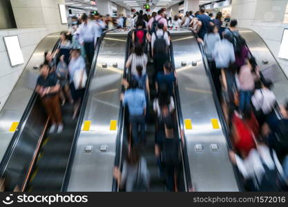 Crowd of Pedestrians Unrecognizable walking in escalator in rush hour morning before working time in subway transportation hub, Hong Kong, Central District, fast moving and business people concept